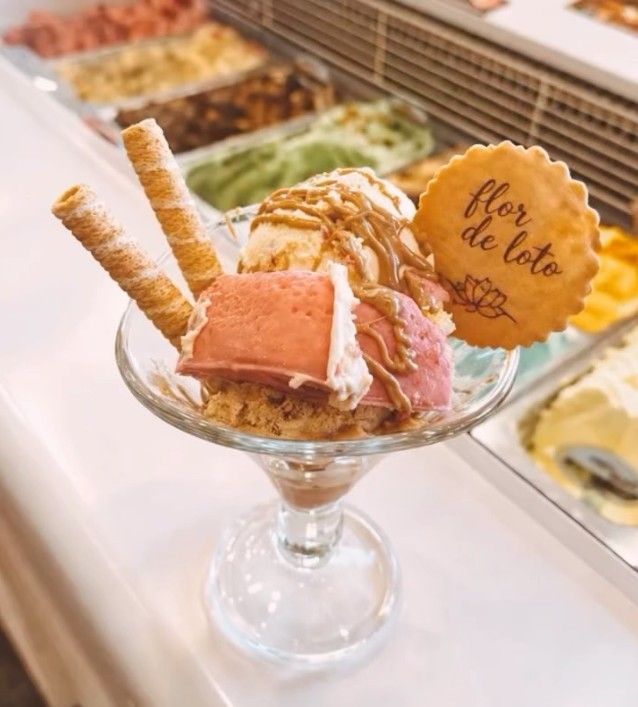 Helado en un plato de cristal con barquillos y un cartel que dice “flor de loto”.