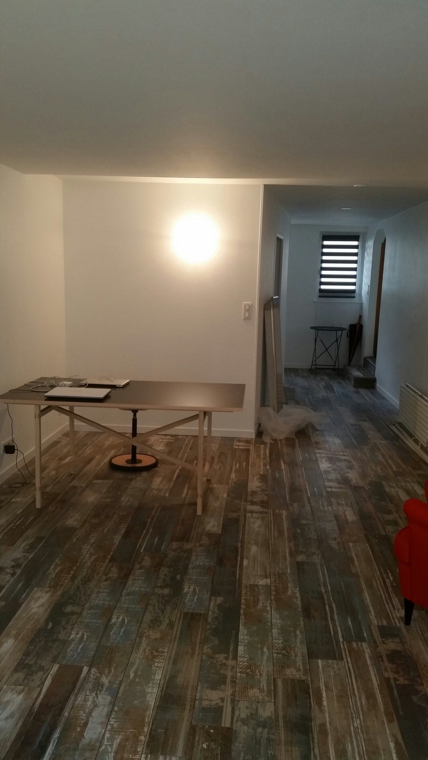 Escalier au fond d'une grande pièce vide aux murs gris