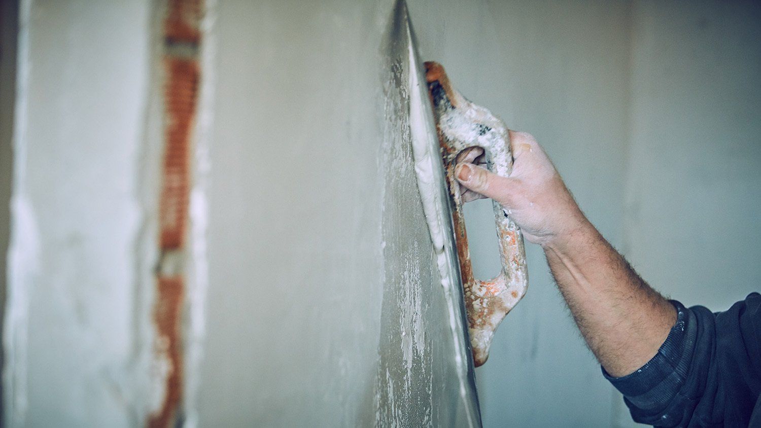 Ouvrier qui pose de l'enduit à la chaux