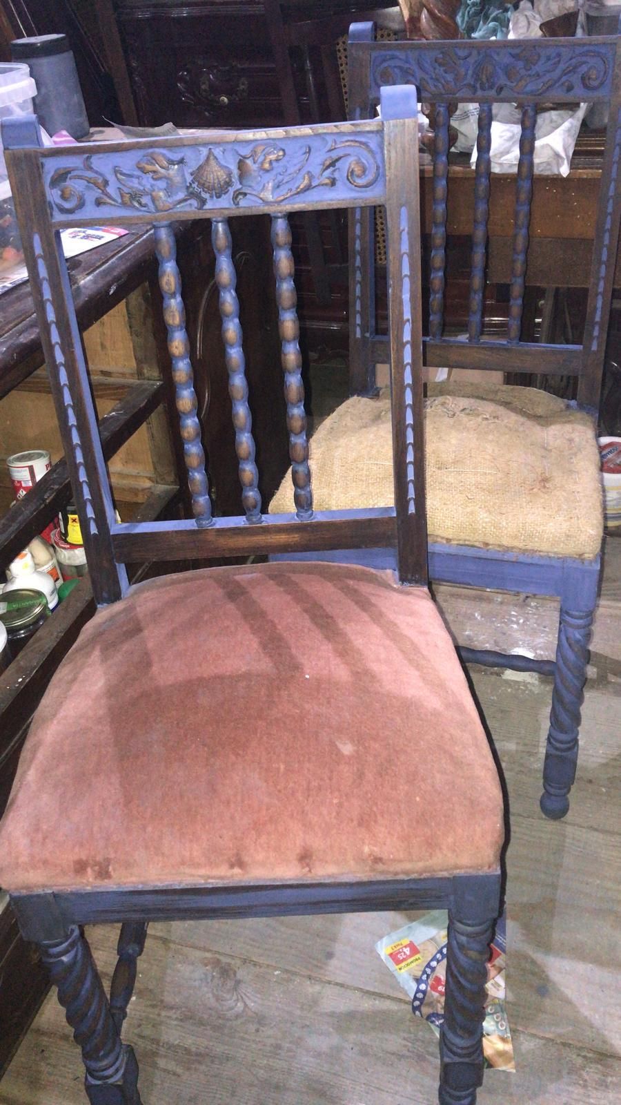 Dos sillas ornamentadas con marcos azules y cojines de diferentes colores.