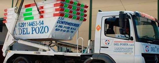 Un camión volquete blanco con la palabra del pozo en el costado está estacionado frente a un edificio.