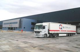 Un camión blanco está estacionado frente a un edificio grande.