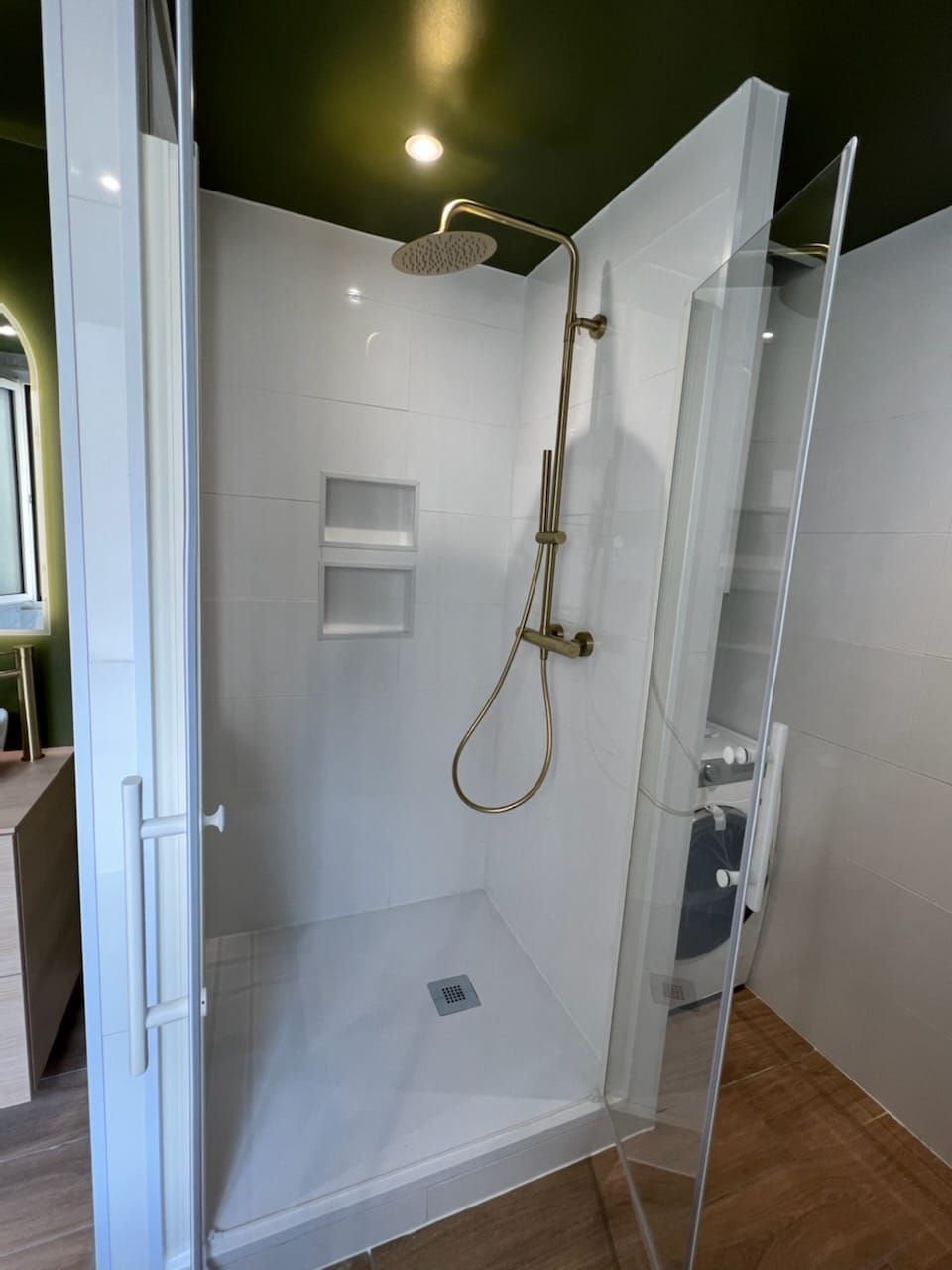 Cabine de douche à côté d'une machine à laver