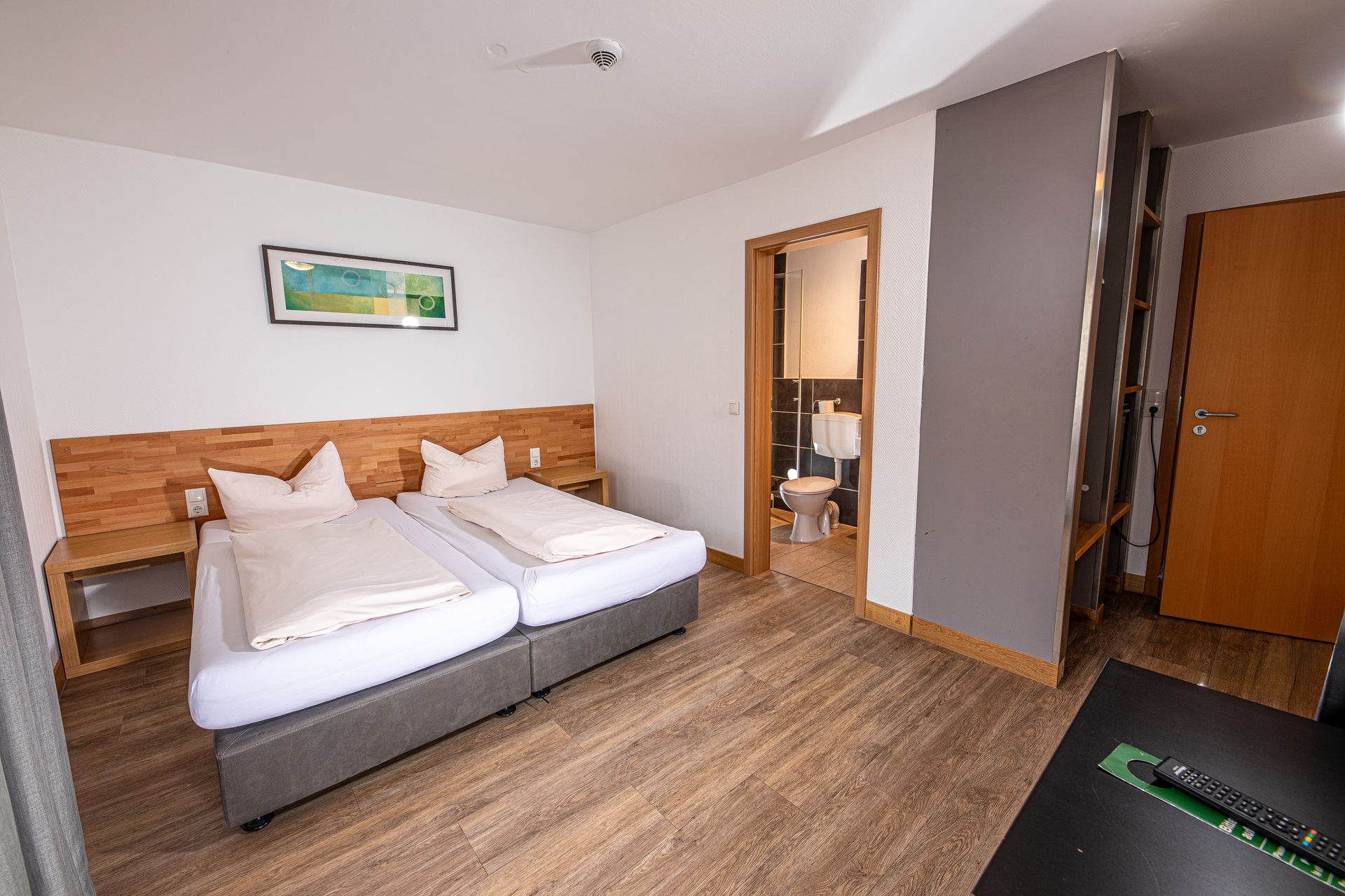 Hotelzimmer mit zwei gemütlichen Betten und Holzmöbeln im Gasthof Lamm