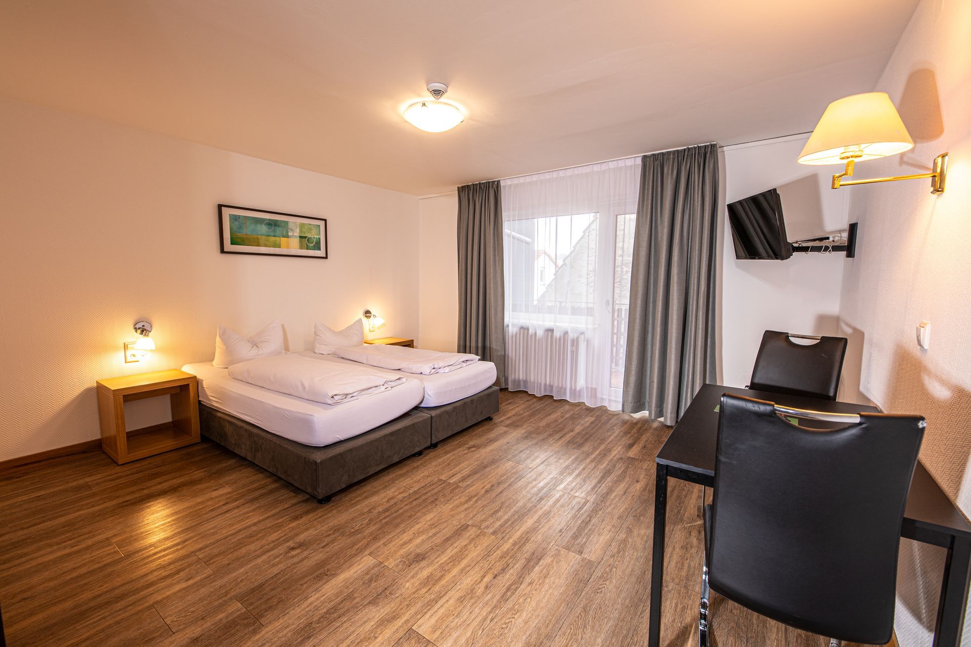 Hotelzimmer mit Doppelbett, Schreibtisch und großem Fenster im Gasthof Lamm