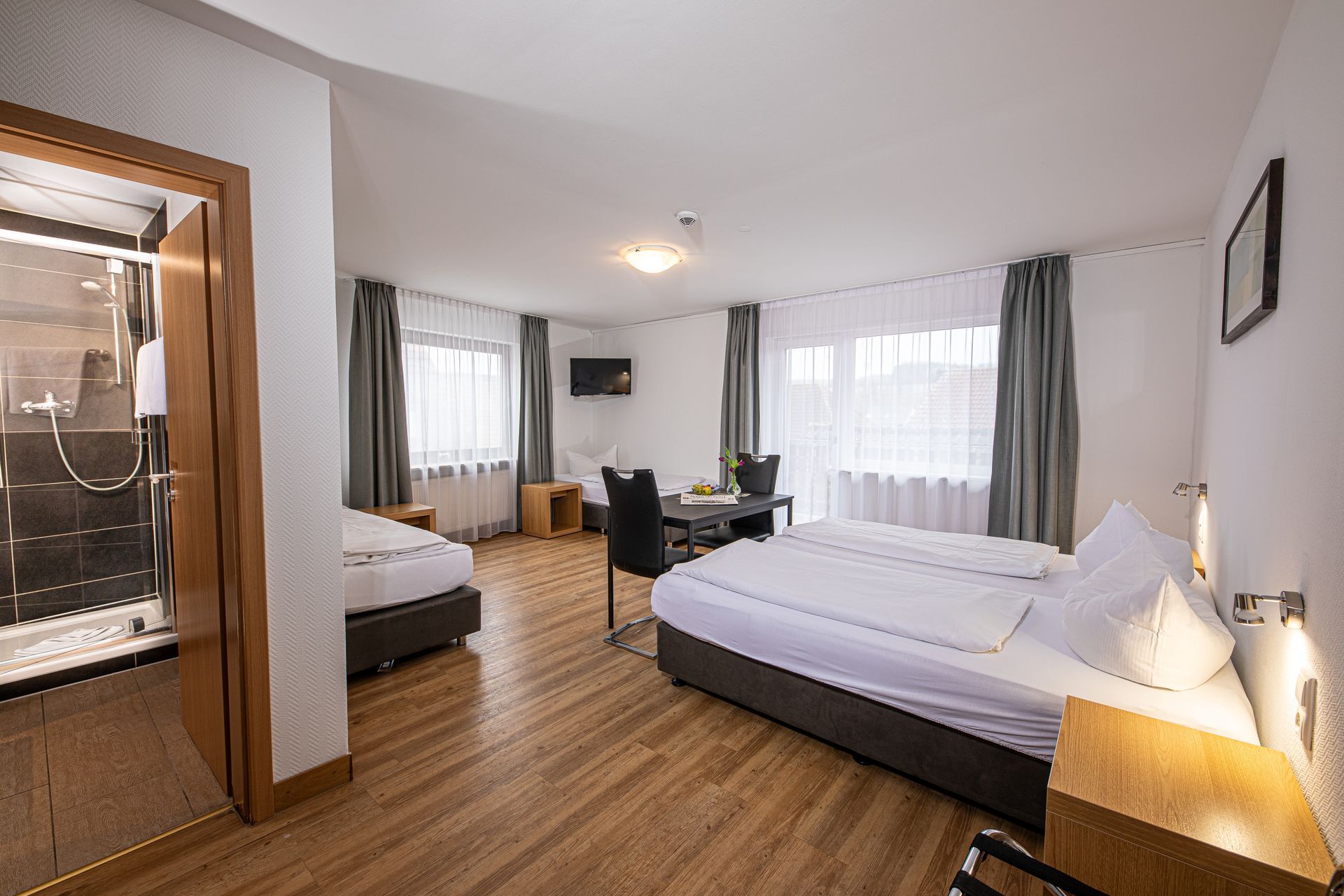 Helles Familienzimmer mit vier Betten und Sitzecke im Hotel Gasthof Lamm.