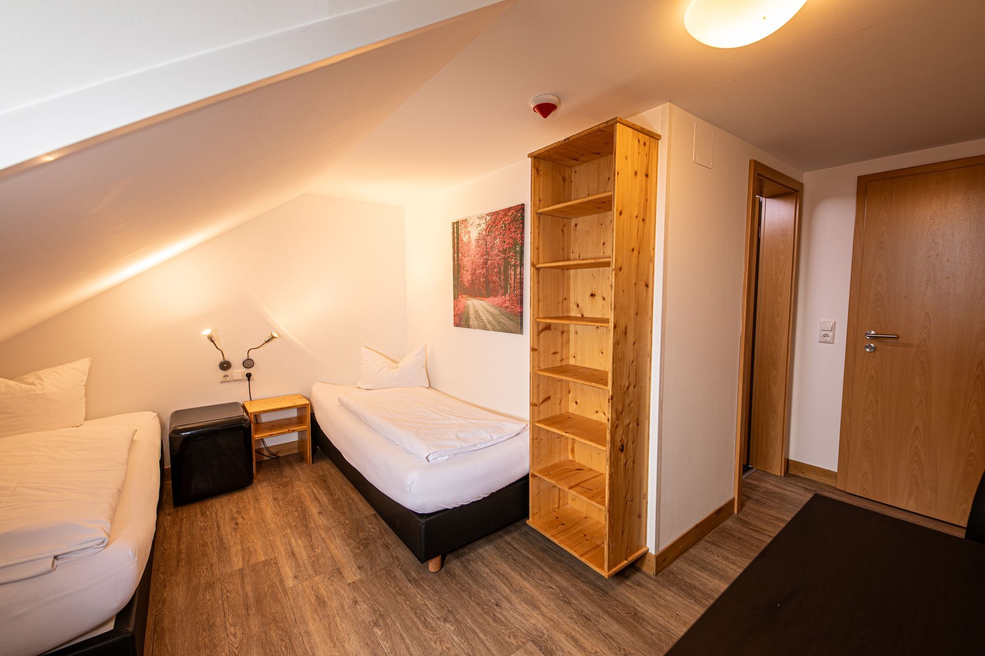 Kleines Zimmer mit Dachschräge, vier Betten und Schrank im Hotel Gasthof Lamm
