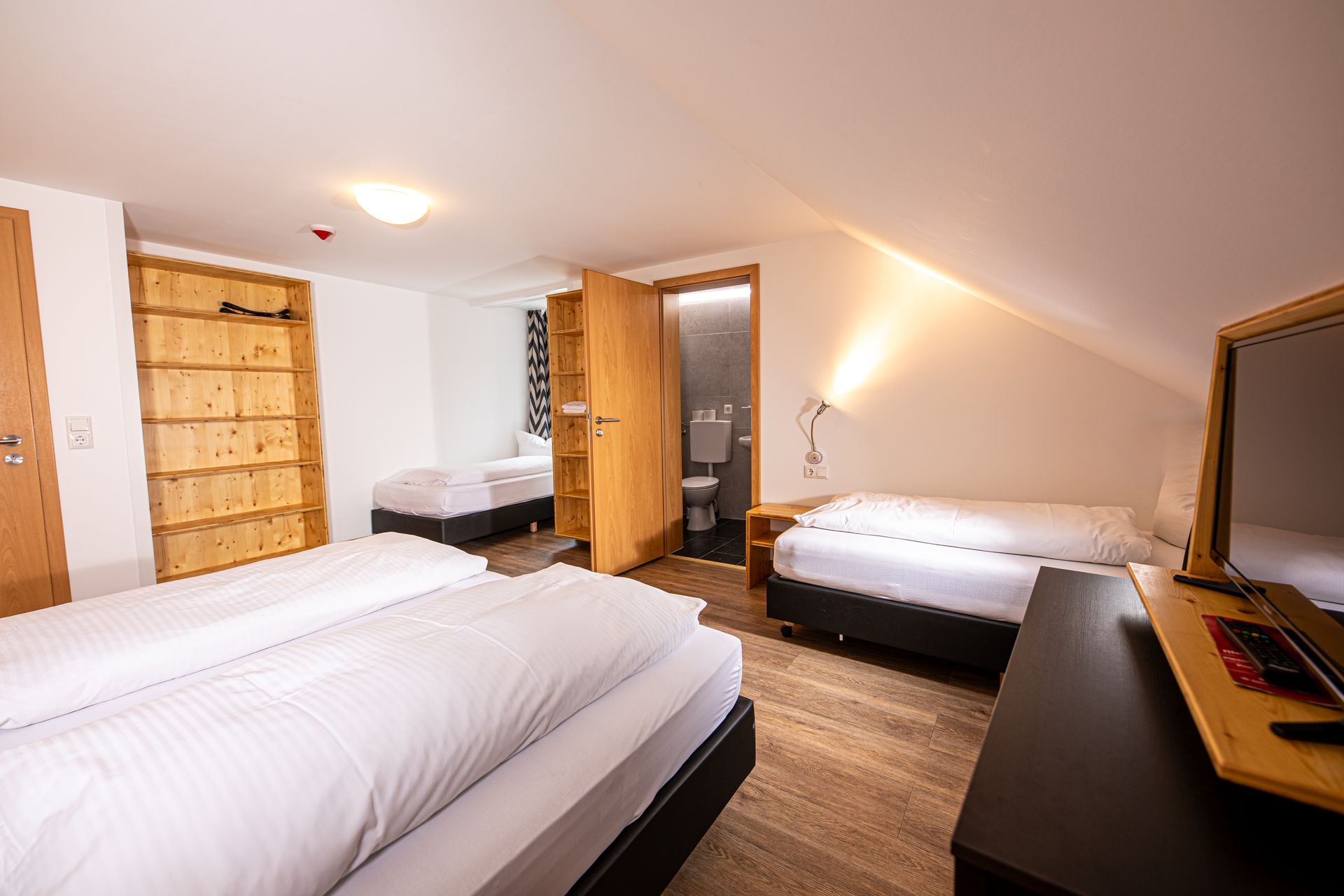 Gemütliches Hotelzimmer im Gasthof Lamm mit Dachschräge und vier Betten