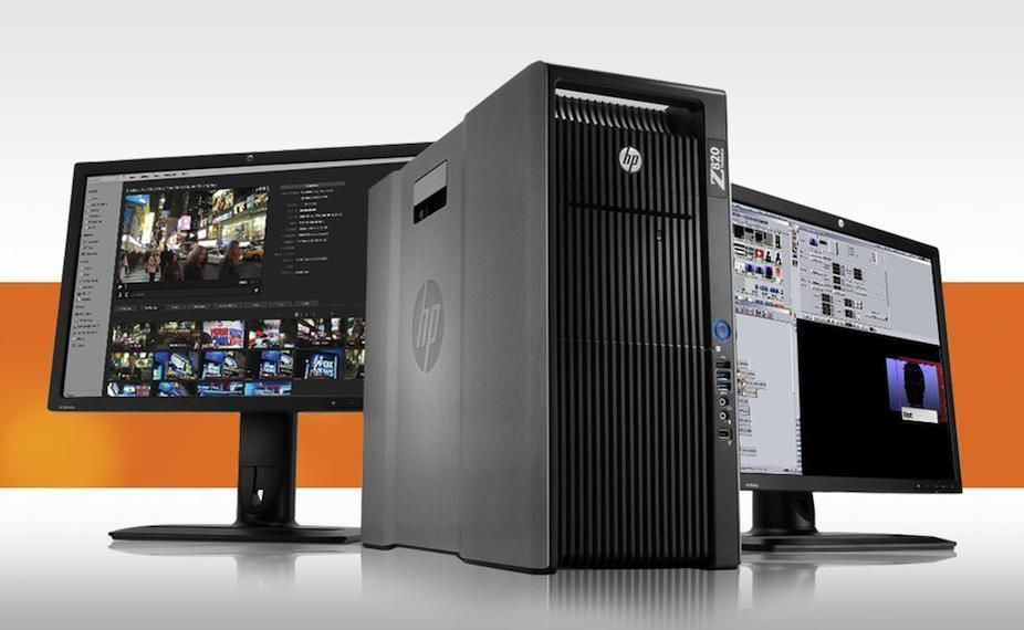 Computadora de escritorio HP con dos monitores sobre una superficie blanca, fondo naranja.