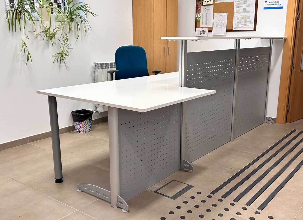 Mostrador de recepción curvo de color rojo y blanco con una silla de oficina de color negro y rojo.