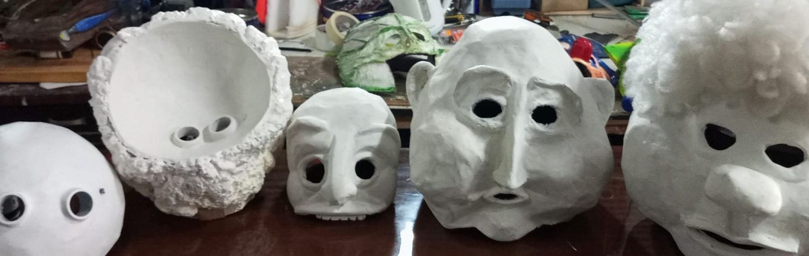 Primer plano de varias máscaras blancas con formas faciales.