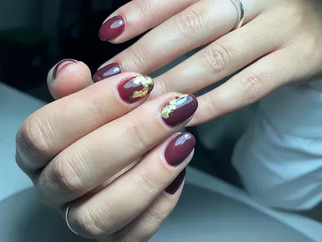 Un primer plano de las uñas de una mujer con un anillo en el dedo.