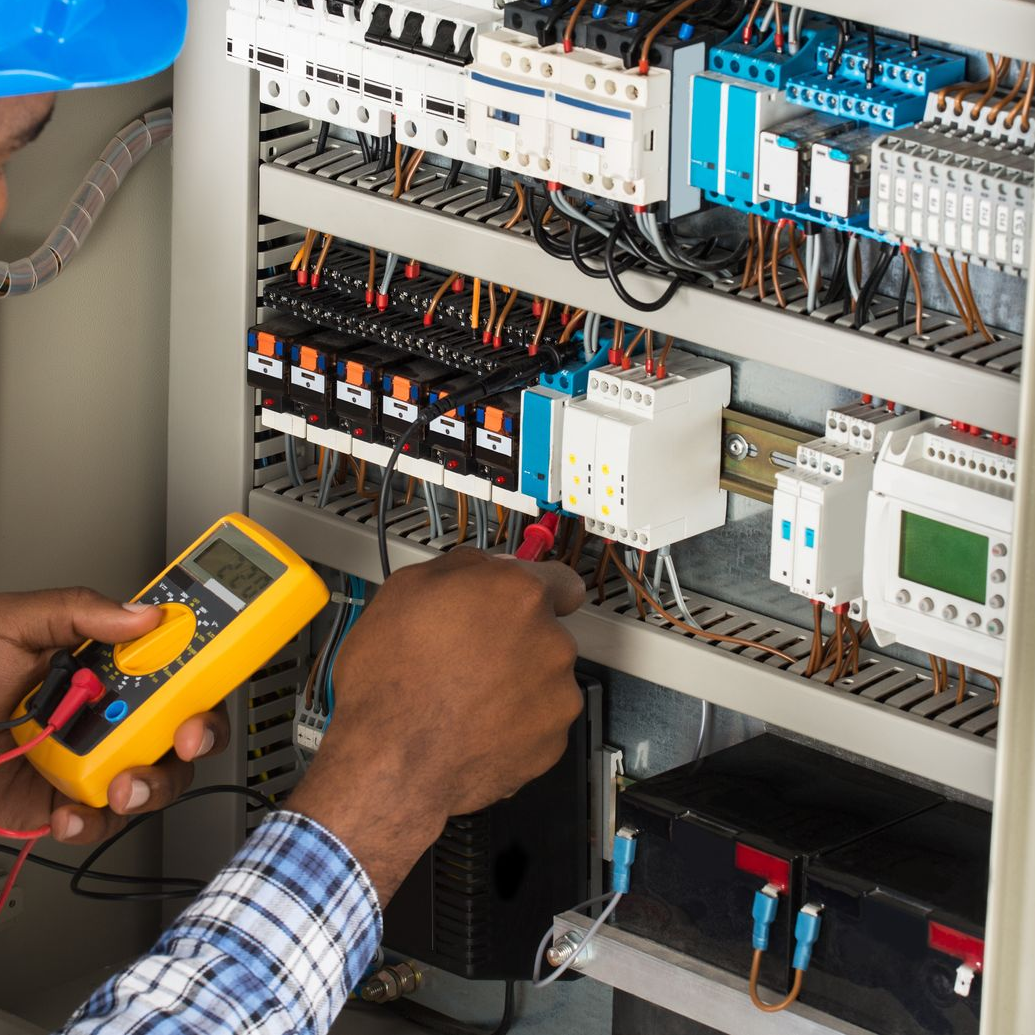 Électricien installant des prises électriques sur un mur blanc