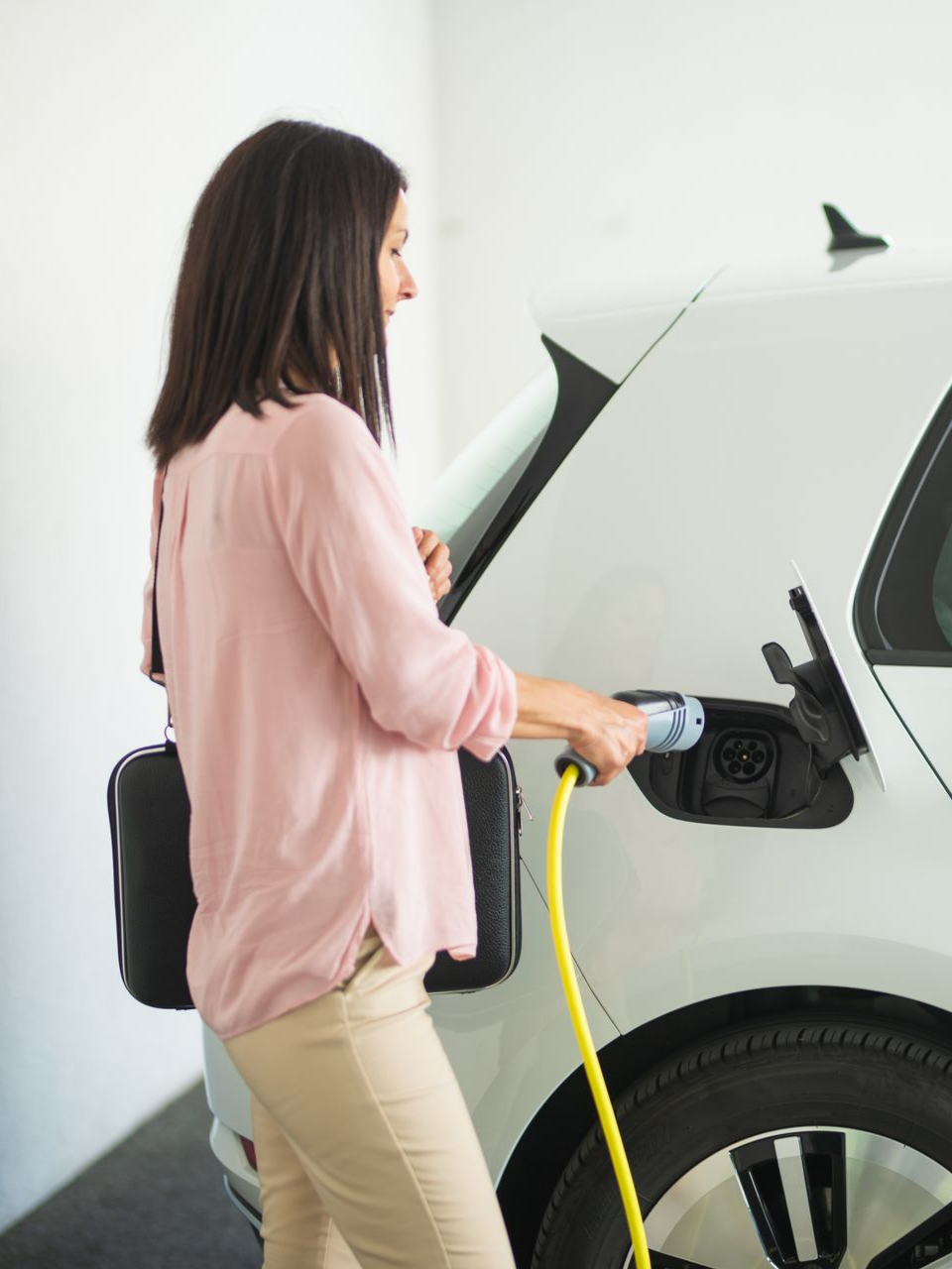 Femme en train de brancher sa voiture électrique pour la recharger