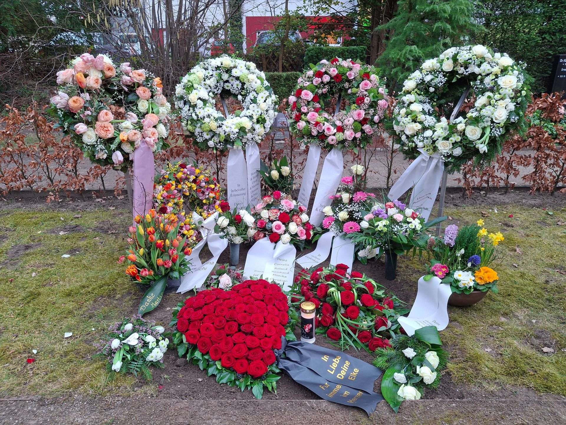 Auf dem Boden liegen ein Blumenstrauß und Kränze.