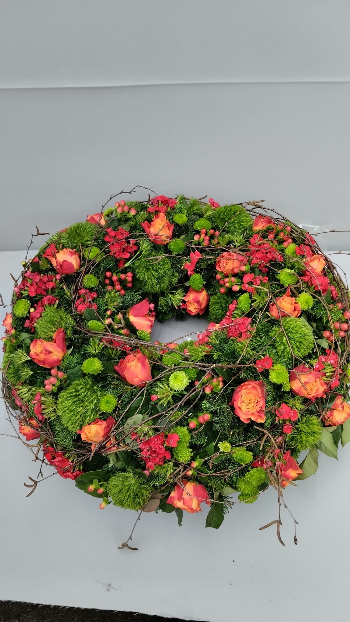 Auf einem weißen Tisch steht ein Blumenkranz.