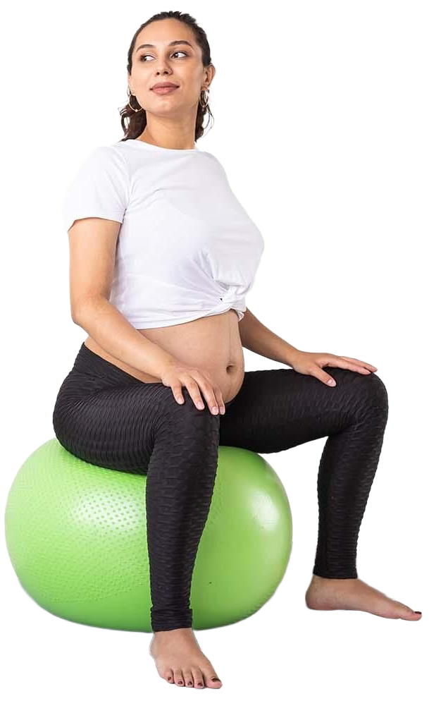 Femme assise sur un ballon d'exercice vert, vêtue d'une chemise blanche et d'un legging noir, dans un studio