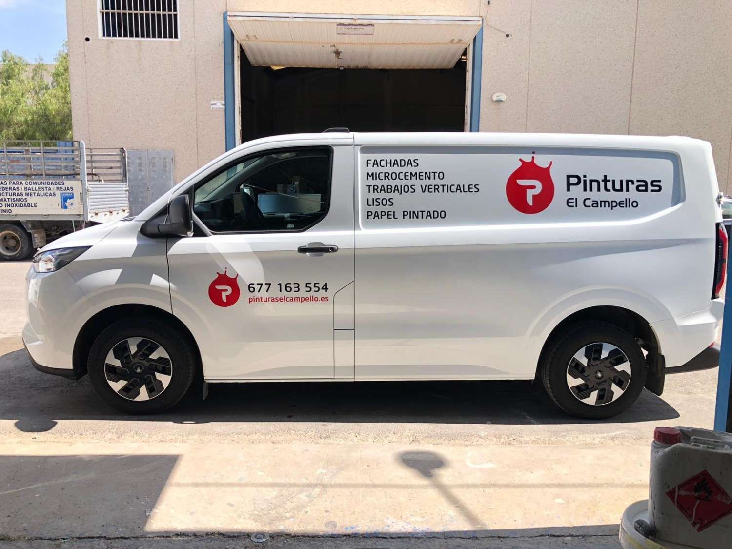 Una furgoneta de trabajo blanca aparcada en el exterior con el logotipo y el texto 