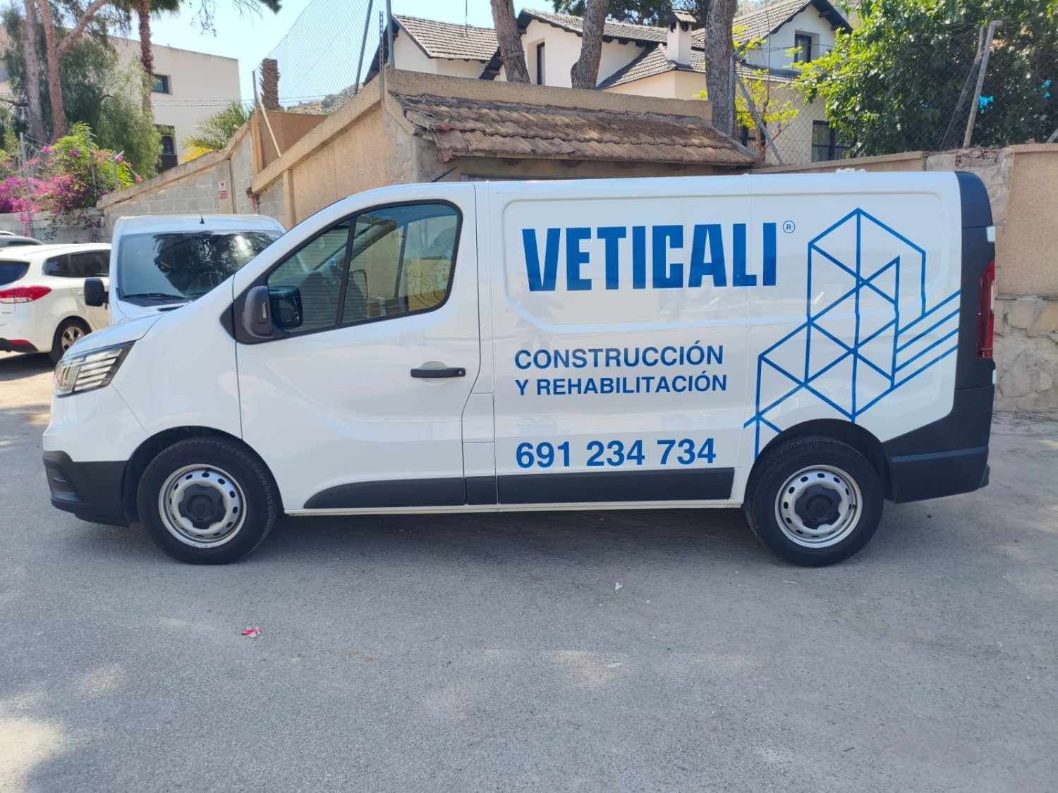 A white work van parked outdoors, labeled with 