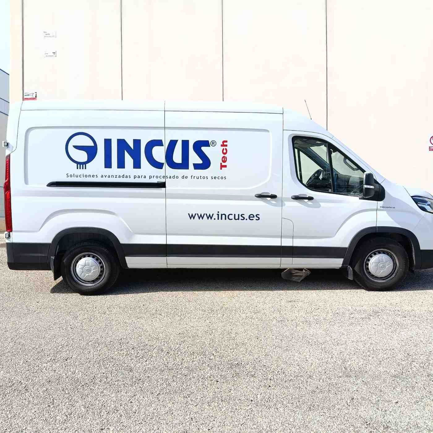 Una furgoneta de trabajo blanca aparcada en el exterior con el logotipo azul de INCUS Tech y la página web impresos en el lateral.