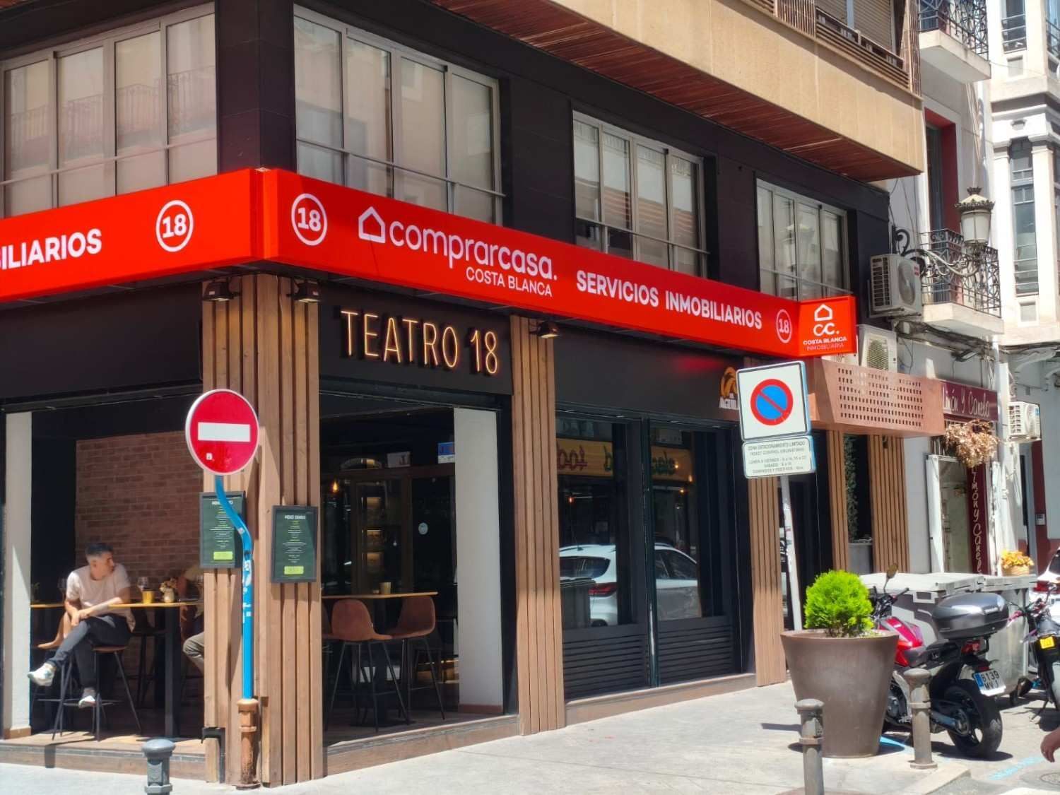 Un local comercial en una esquina, con un letrero rojo de 