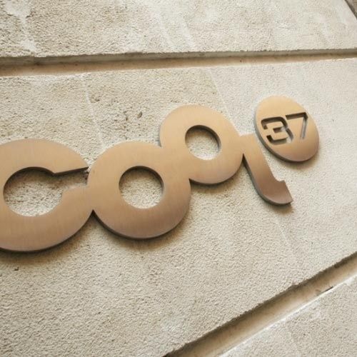 Un letrero escultórico metálico de color bronce con la inscripción 