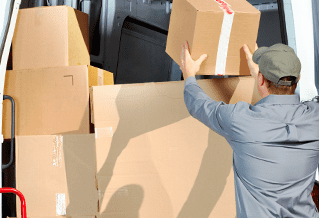 Persona cargando cajas de cartón en una furgoneta.