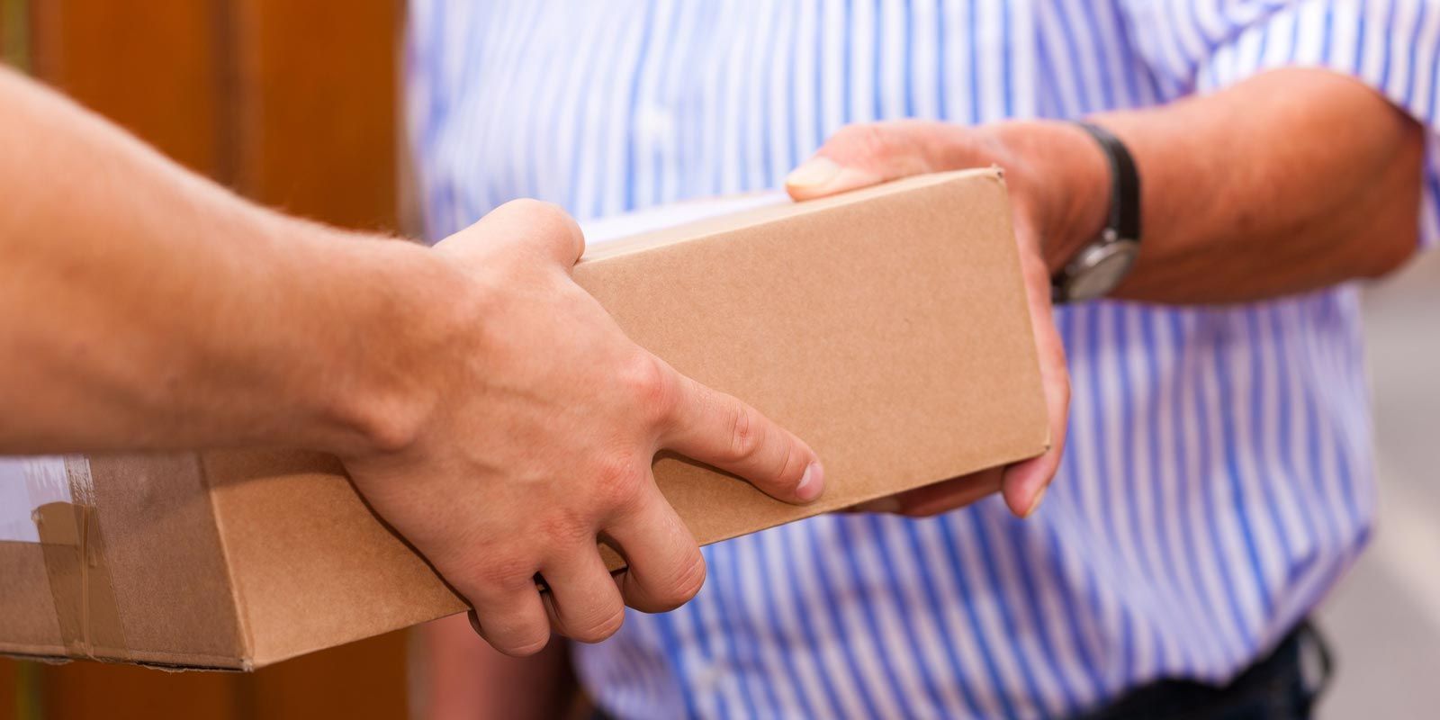 Durante el traspaso de una caja de cartón, las personas intercambian una caja de cartón.