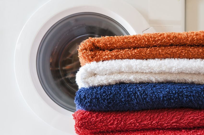 Saubere Badetücher vor einer Waschmaschine