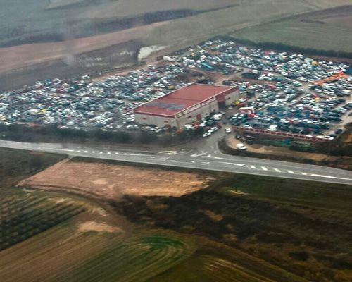 Una vista aérea de un gran estacionamiento lleno de muchos autos.