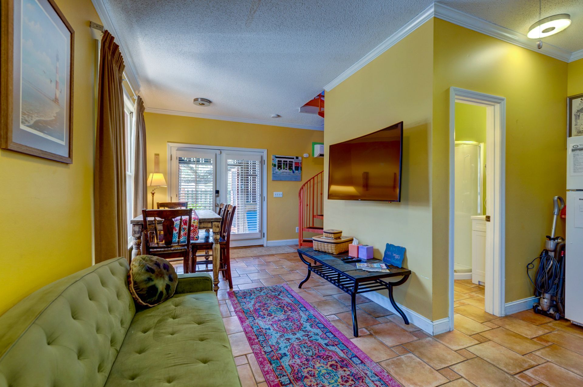 A living room with a green couch and a table