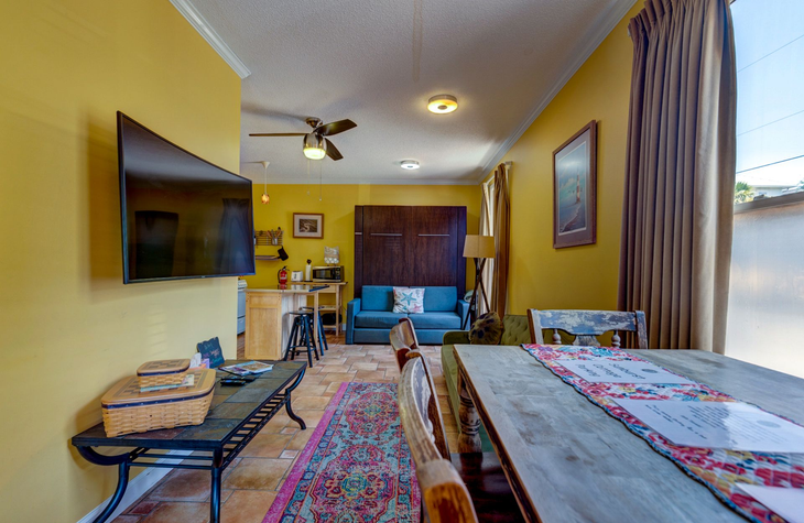 A living room with a green couch and a table