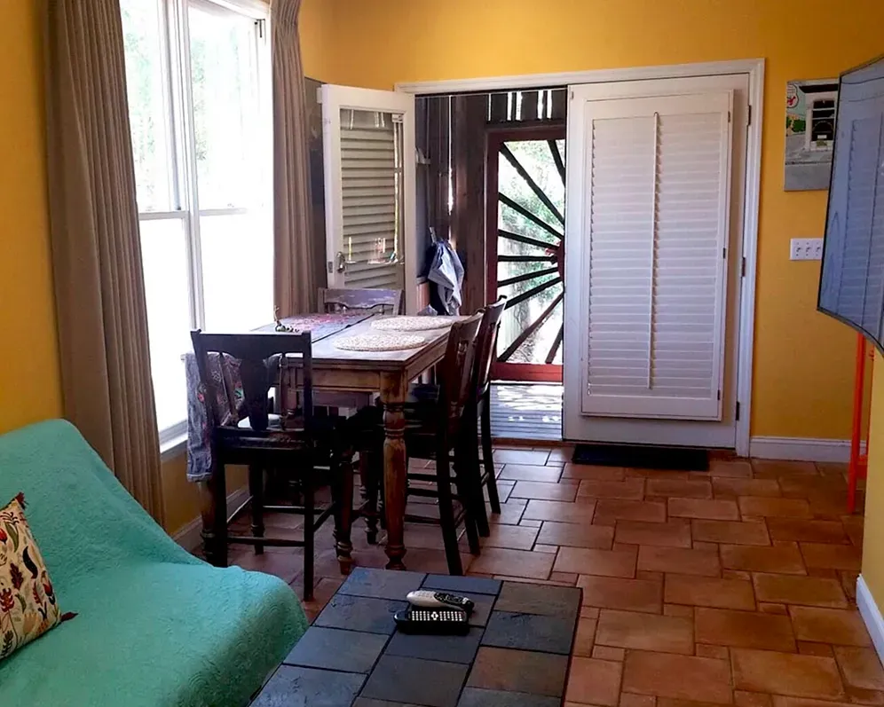 A living room with a green couch and a table