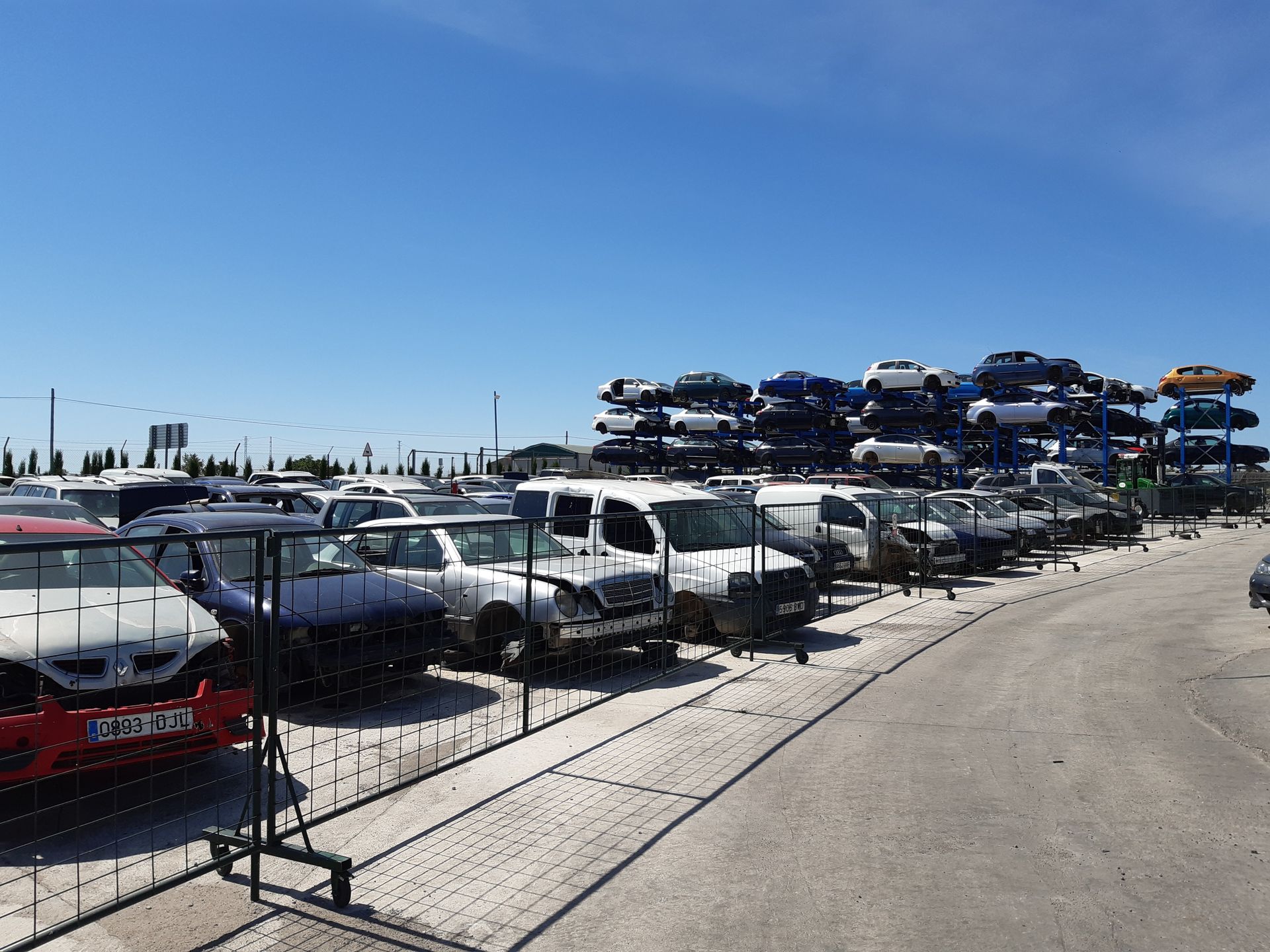 Hay muchos coches apilados uno encima del otro en un estacionamiento.