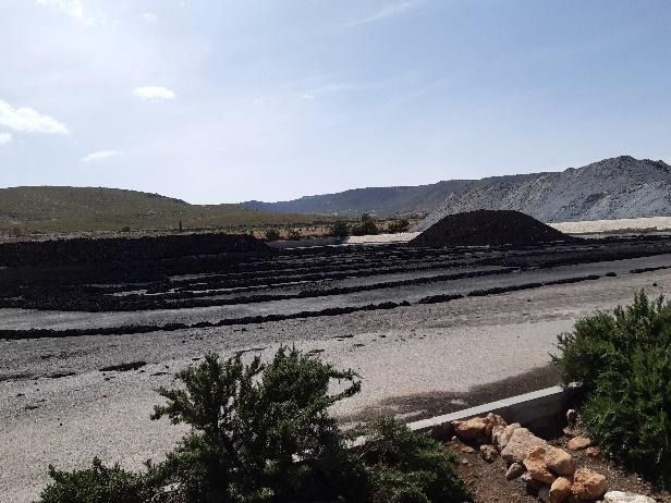Un gran montón de tierra se encuentra al costado de una carretera.