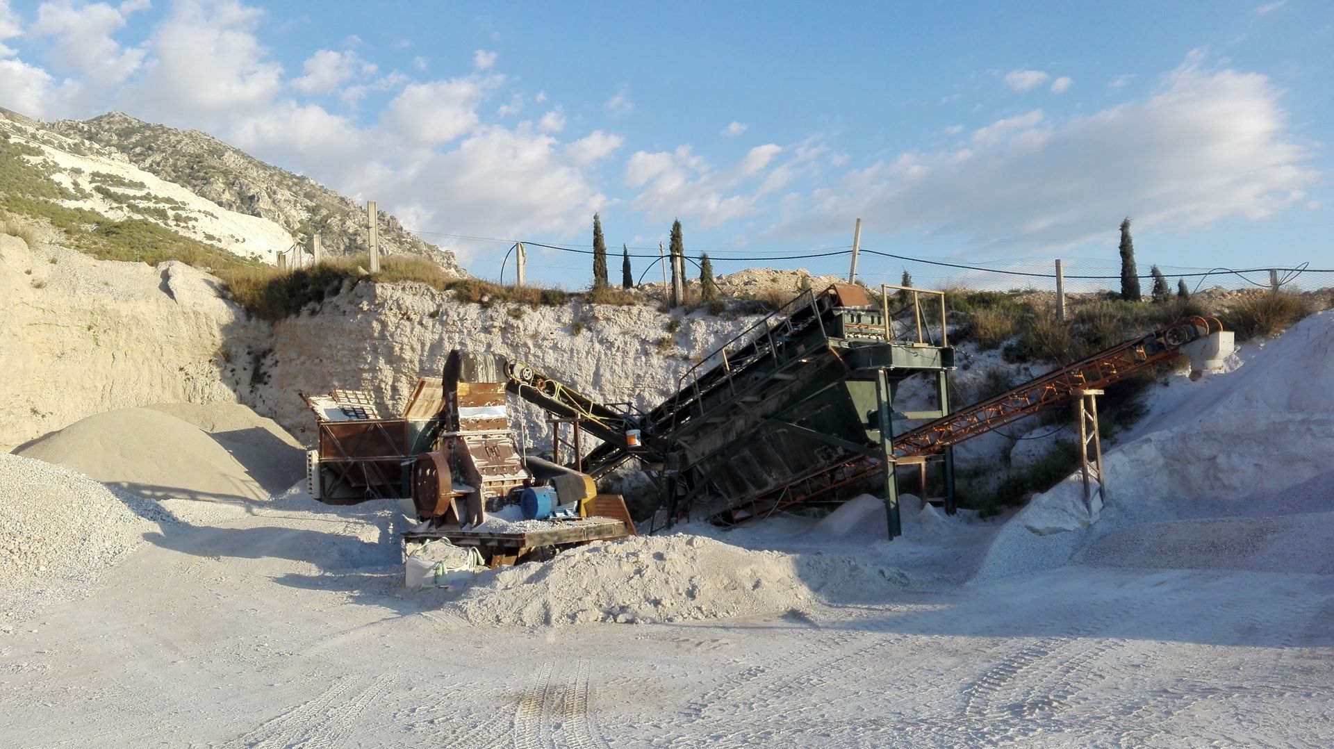 Una gran pila de rocas en una cantera con montañas al fondo.