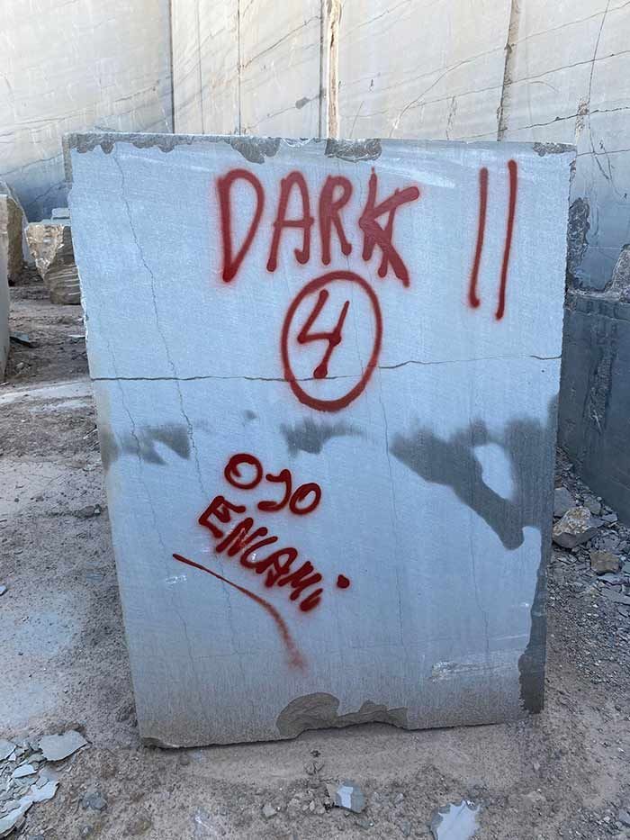 Bloque de piedra gris con texto pintado con aerosol rojo: