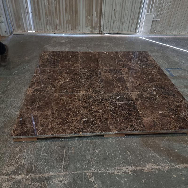 Grandes baldosas de mármol marrón sobre un palé de madera en un almacén.