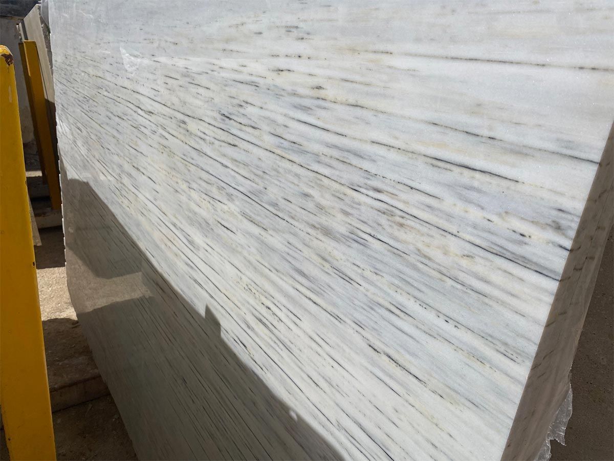 Primer plano de una losa de mármol blanco con vetas grises.