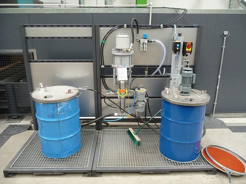 Zwei blaue Fässer stehen nebeneinander auf einer Metallplattform