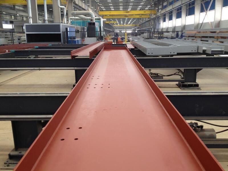 Ein großer roter Metallträger befindet sich in einer Fabrik
