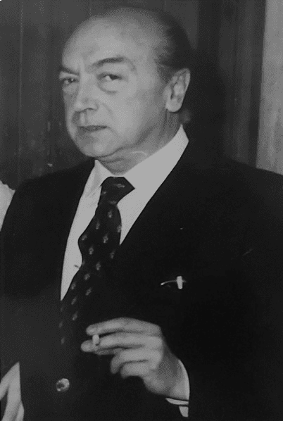 Hombre de traje con un cigarrillo en la mano. Foto en blanco y negro.