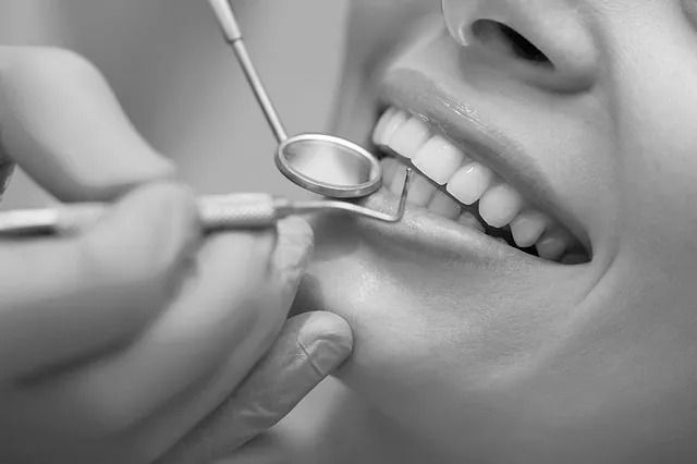 Dentista examinando dientes con espejo y sonda. Primer plano de la boca de un paciente.