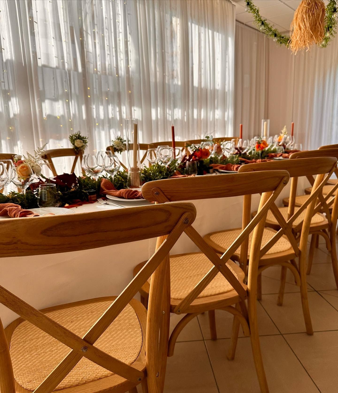 Élégante table de repas ornée de fleurs, de bougies, de verres et de serviettes pliées.