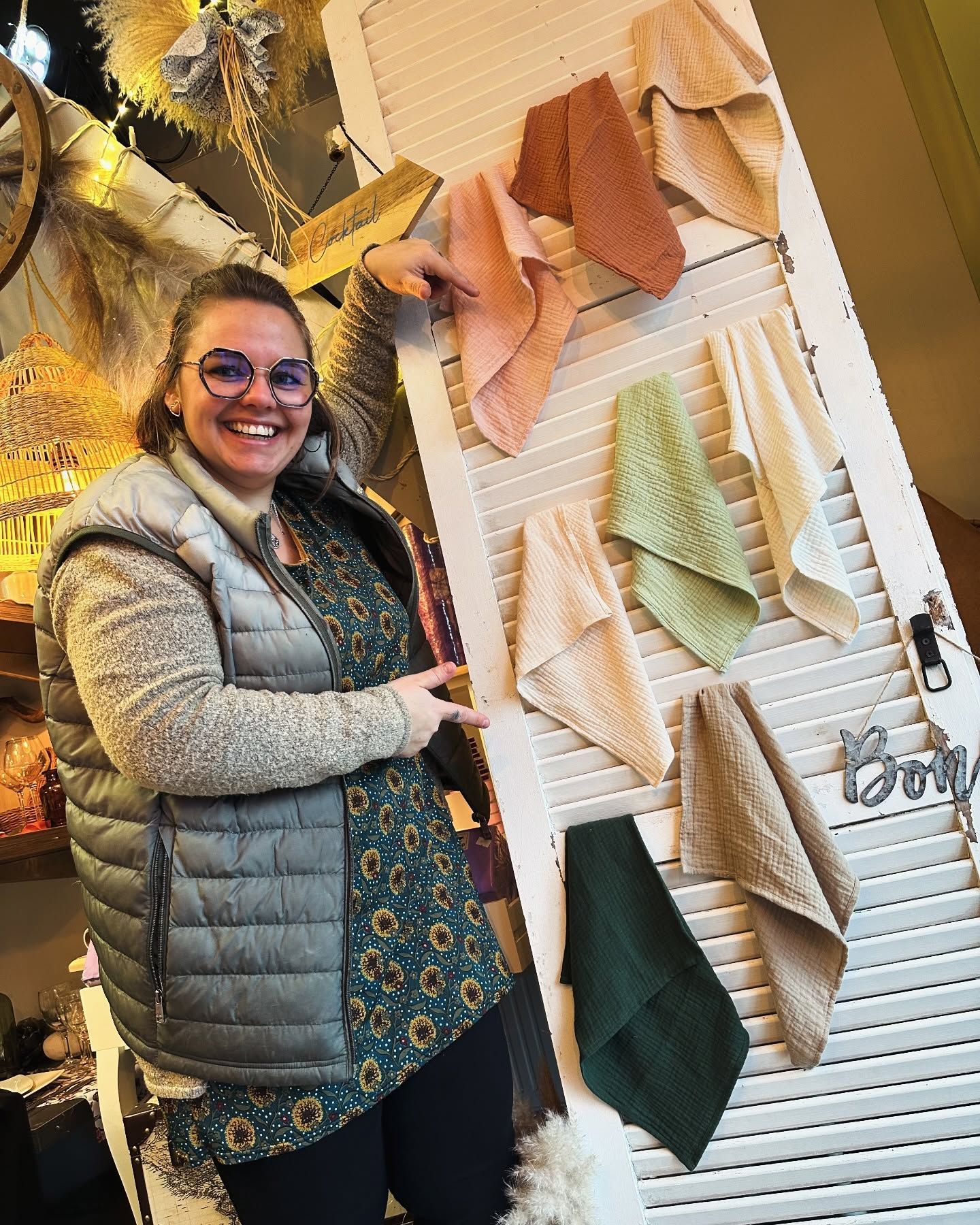 Une employée de la boutique qui présente du linge de table.
