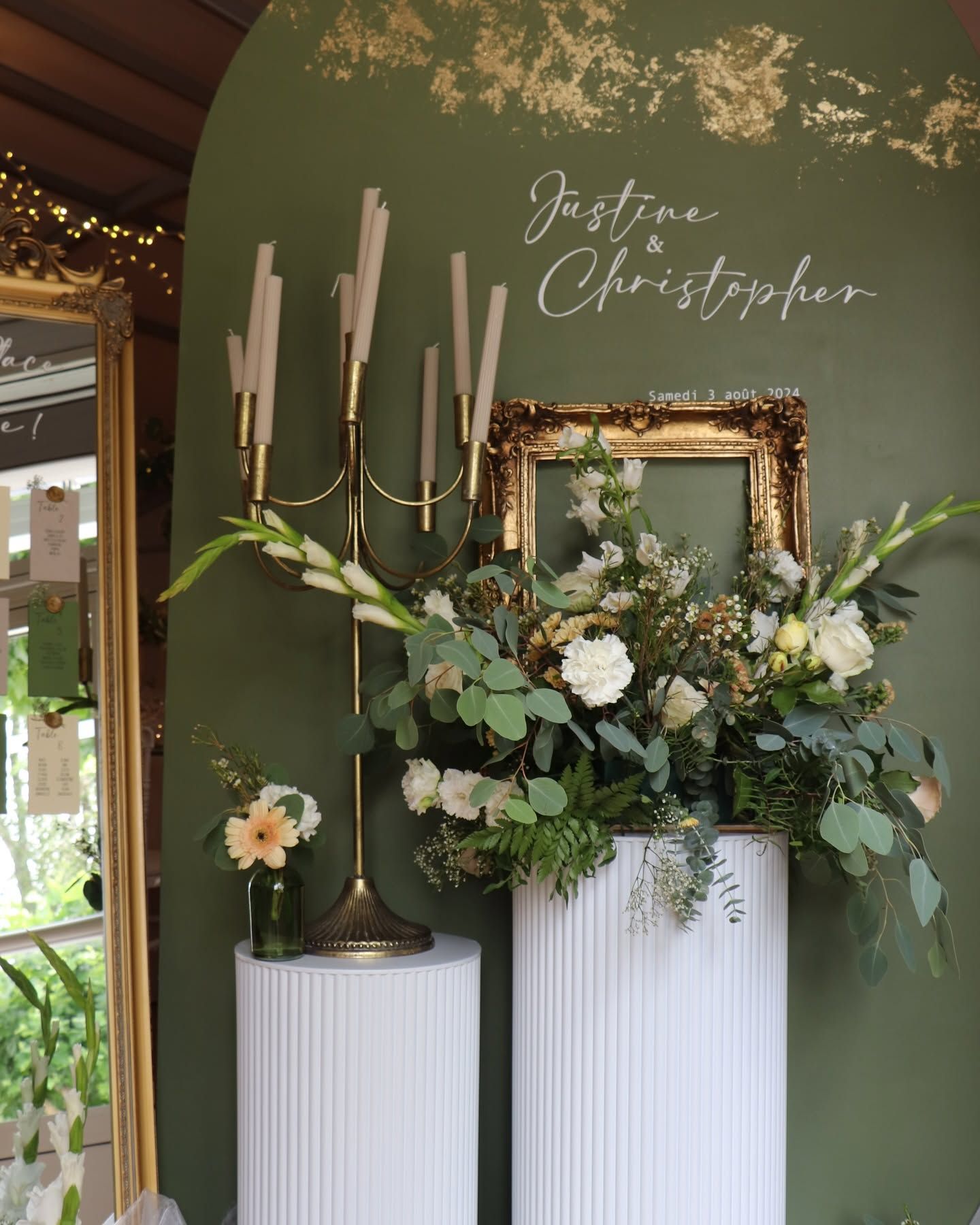 Élégante décoration florale pour un mariage, avec un fond vert, et un bougeoir.