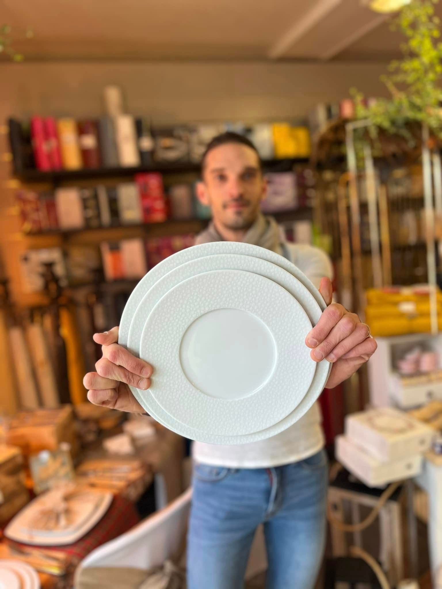 Un employé de la boutique tenant des assiettes.