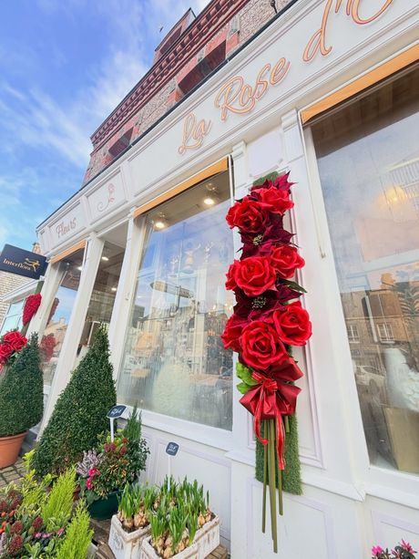 Façade d'une boutique de fleurs avec de décorations florales de roses.
