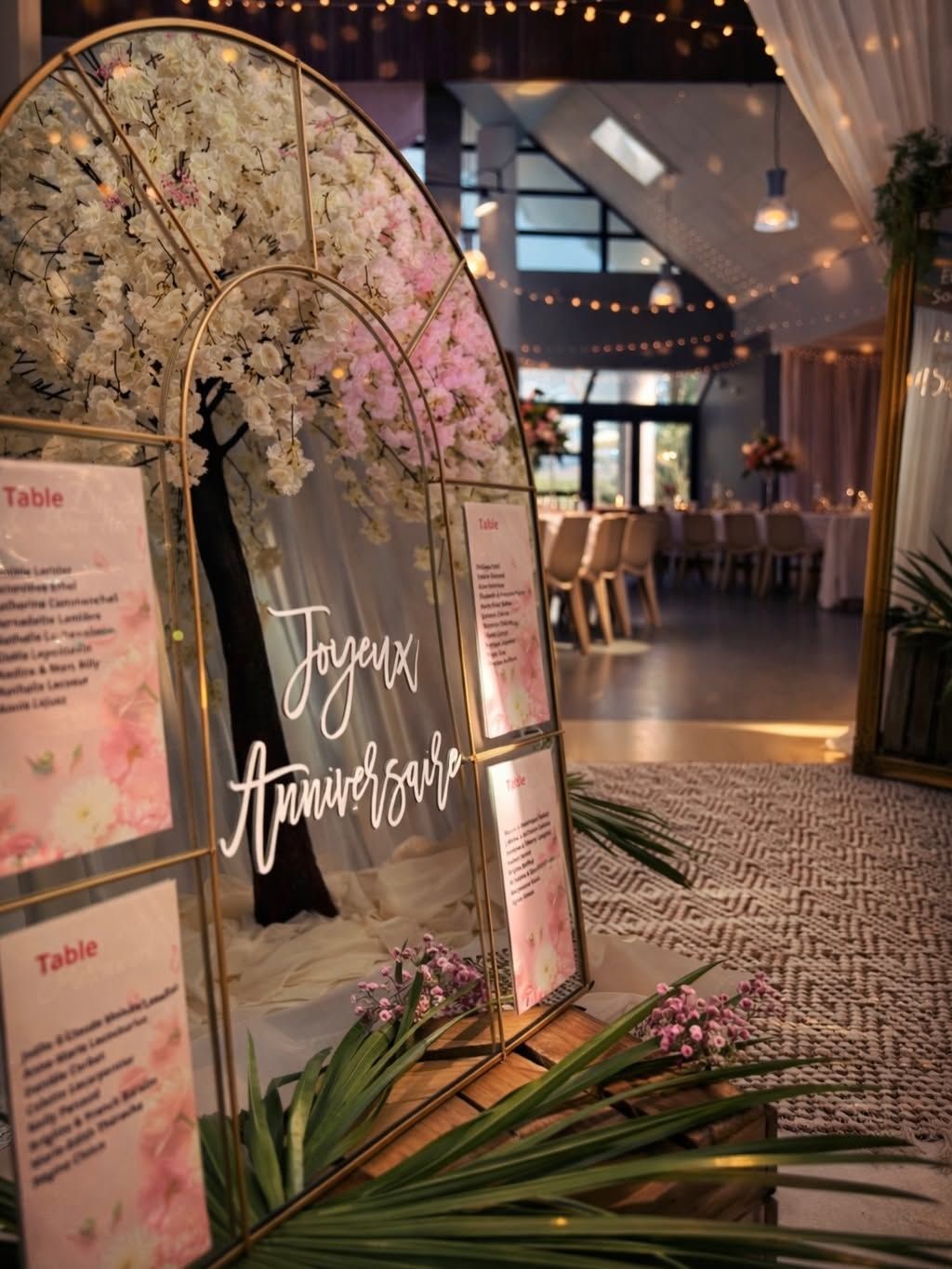Panneau de bienvenue pour un anniversaire avec une arche florale.