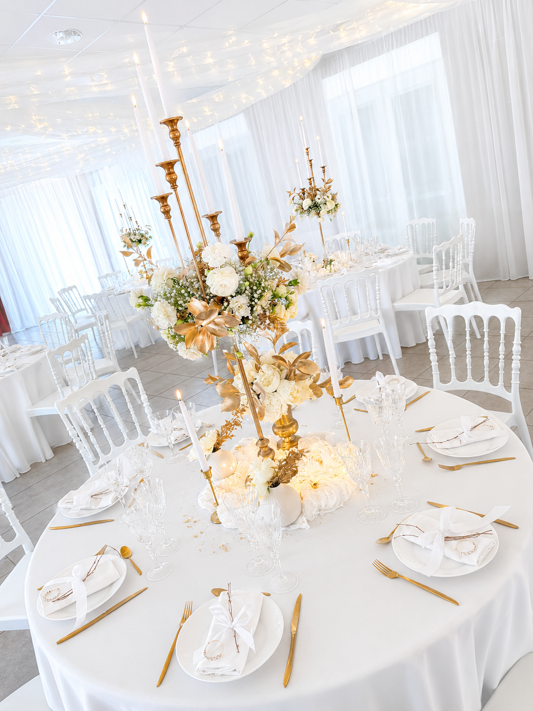 De la vaisselle blanche et dorée présentée sur une table.